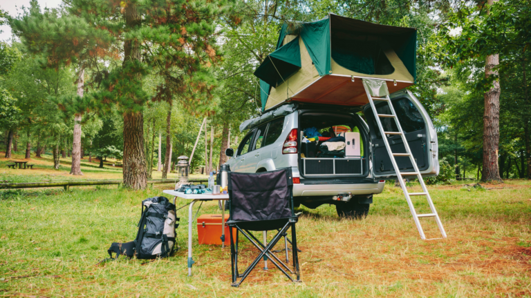 Véhicule 4x4 avec tente de toit stationné dans un cadre paisible pour une aventure en plein air.